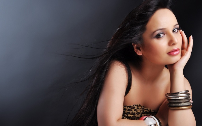 Woman with long dark hair and bracelets