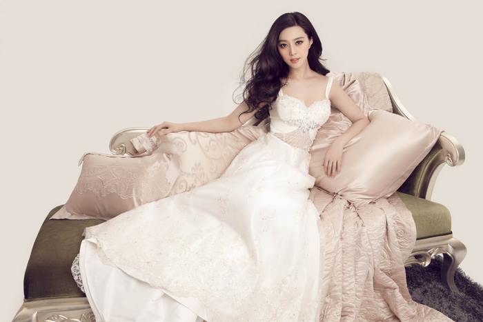 Fan Bingbing in a white dress on a couch