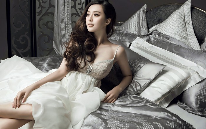 Fan Bingbing in a white dress on a bed