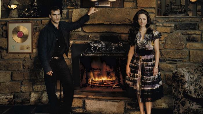 Joaquin Phoenix and woman by fireplace