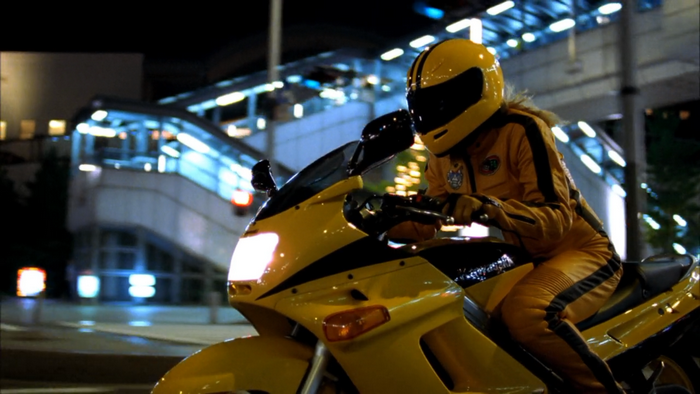 Uma Thurman on a yellow motorcycle