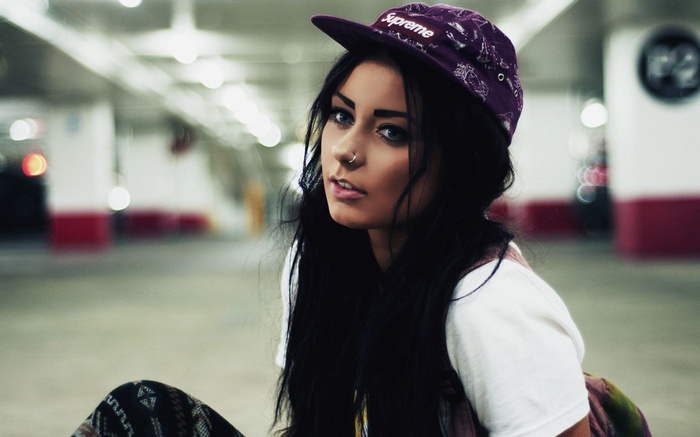 Woman wearing a Supreme hat in a parking garage
