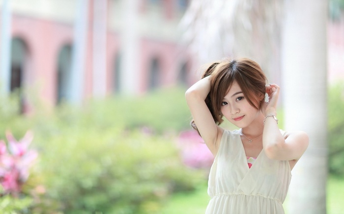 Young woman with hands in her hair outdoors