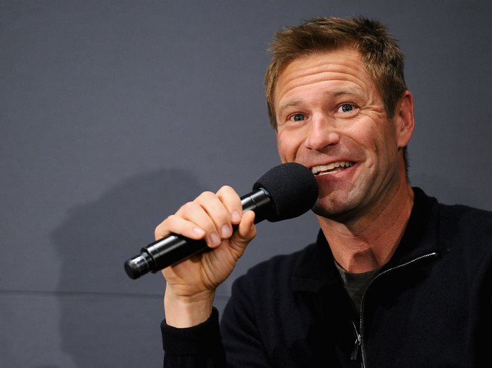 Aaron Eckhart holding a microphone