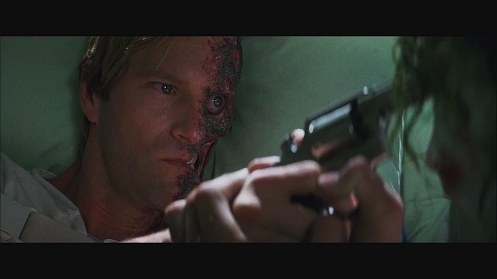 Harvey Dent from The Dark Knight holding a gun