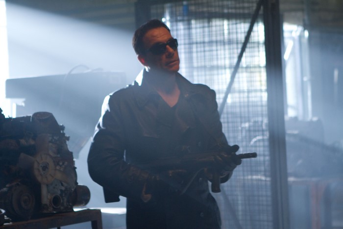 Jean-Claude Van Damme holding a submachine gun