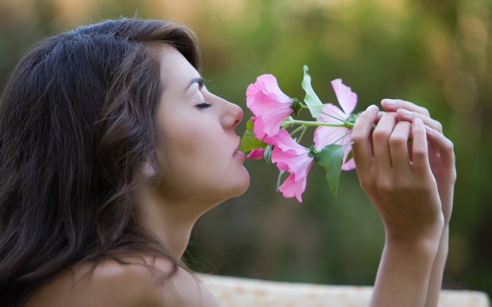 Woman smelling pink flowers