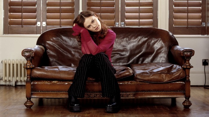 Anna Paquin sitting on a leather couch