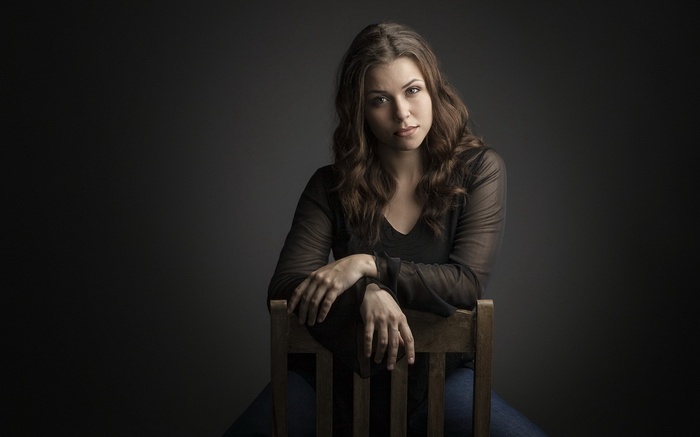 Woman sitting on a wooden chair