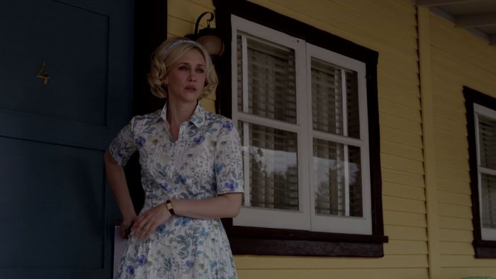 Vera Farmiga standing by a blue door