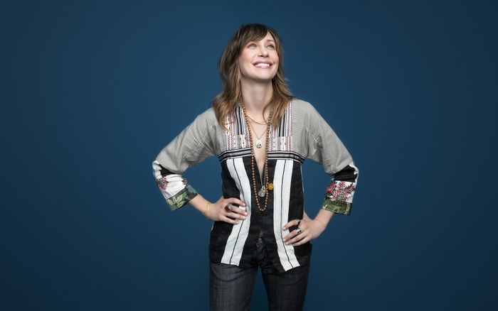 Vera Farmiga posing against a blue background