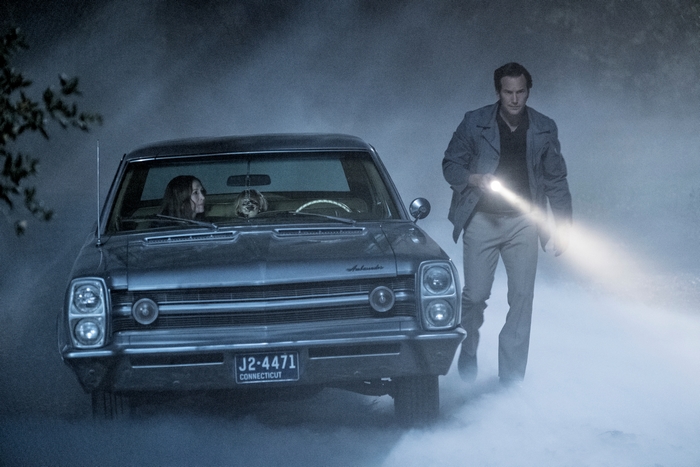 Vera Farmiga in a car with a man holding a flashlight