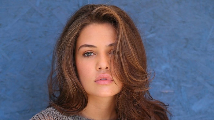 Woman with brown hair in a grey sweater