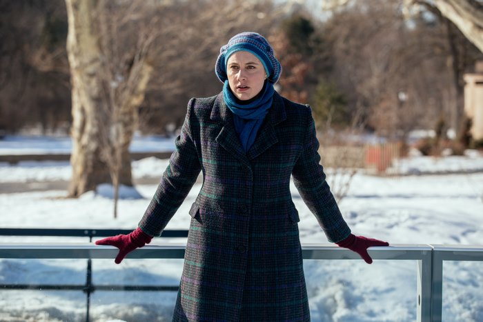Greta Gerwig in a plaid coat and blue hat