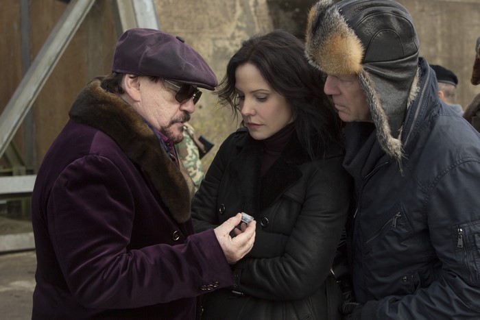 Mary-Louise Parker and two men examining an object