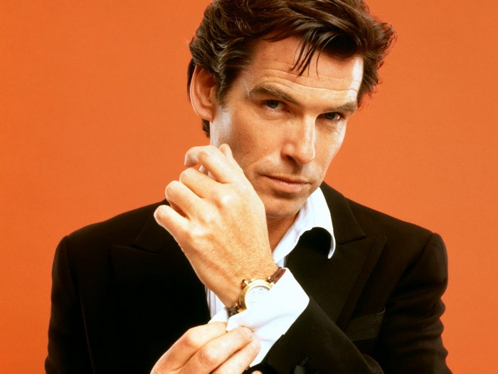Pierce Brosnan adjusting his suit cuff
