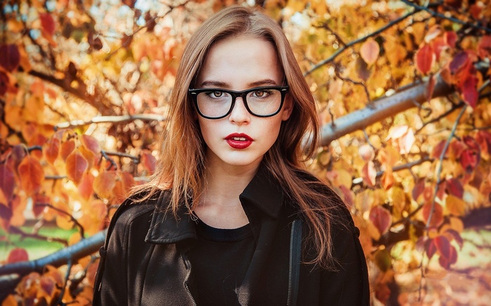 Woman with glasses and red lipstick in autumn