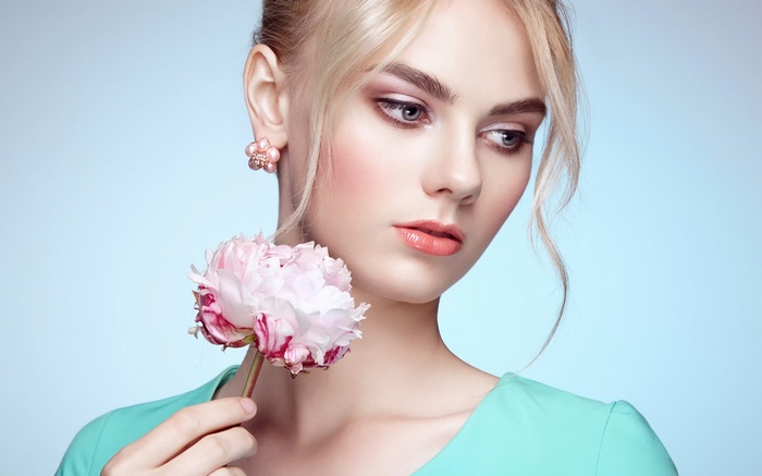 Woman with blonde hair holding a pink peony