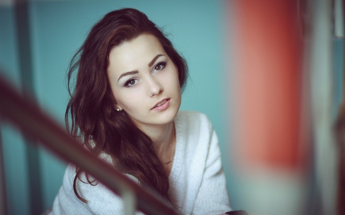 Young woman with brown hair wearing a white sweater