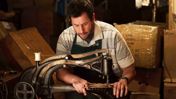 Adam Sandler sewing on a machine