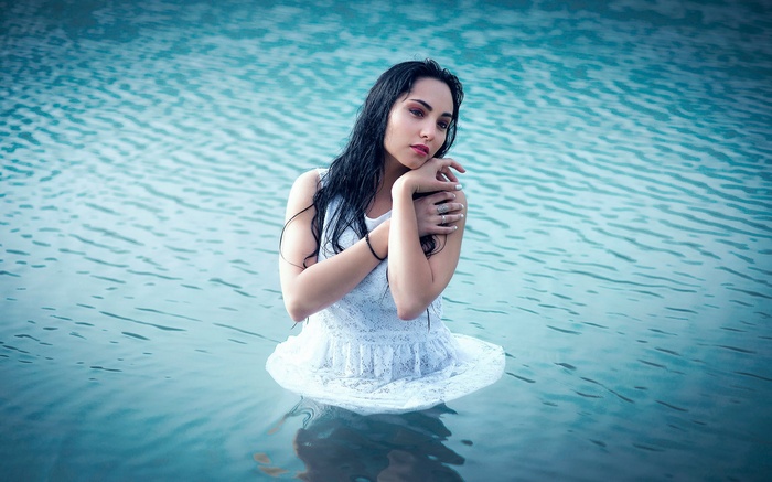 Woman in white dress standing in water