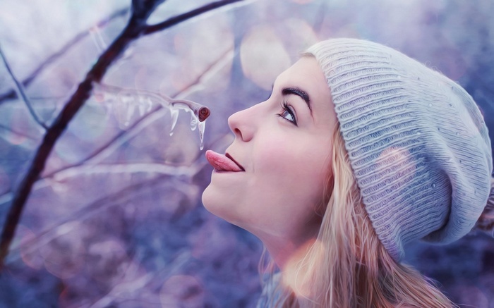 Girl licking icicle from a branch