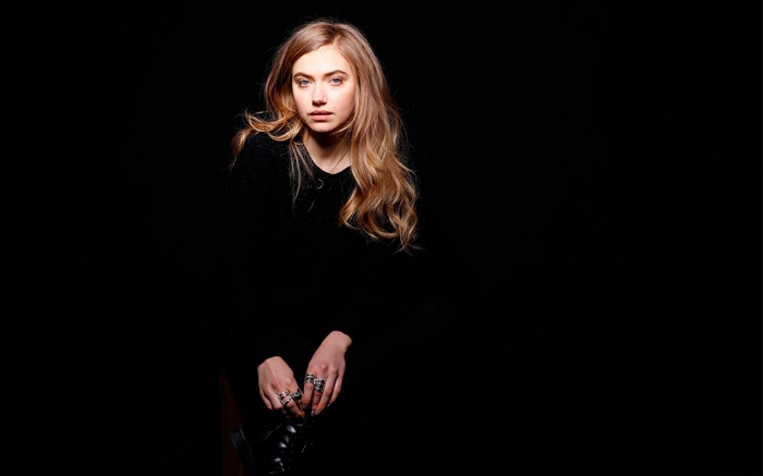 Woman with blonde hair wearing a black top