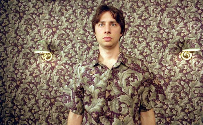 Zach Braff in front of floral wallpaper