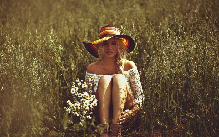 Woman in a wide-brimmed hat in a field