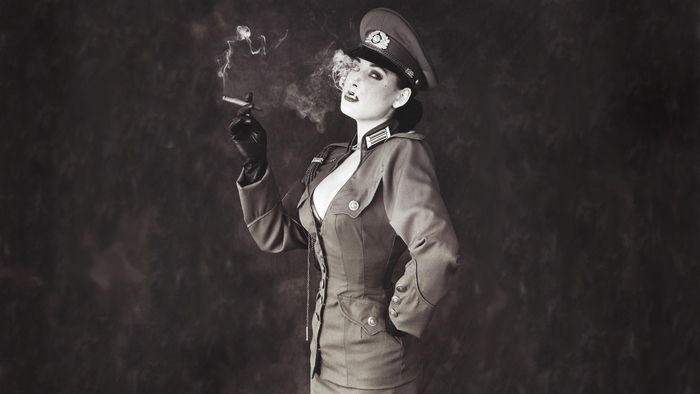 Dita Von Teese in military-style uniform smoking cigar
