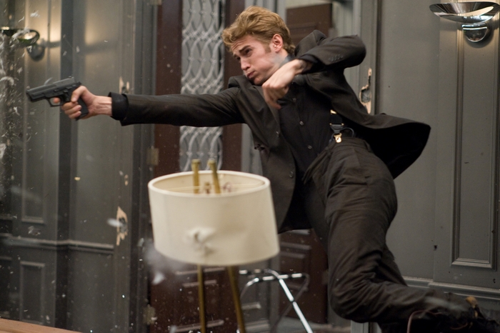 Hayden Christensen in a suit with a gun