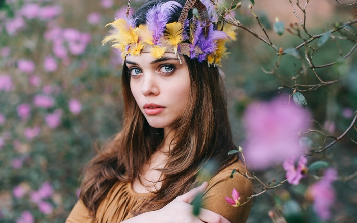 Woman with feather headdress in a garden