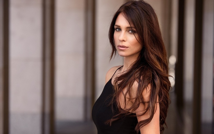 Woman with long brown hair wearing a black top