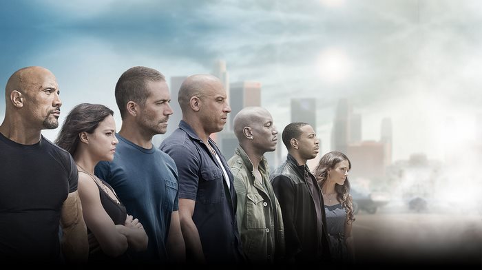 Fast & Furious cast standing in front of city skyline