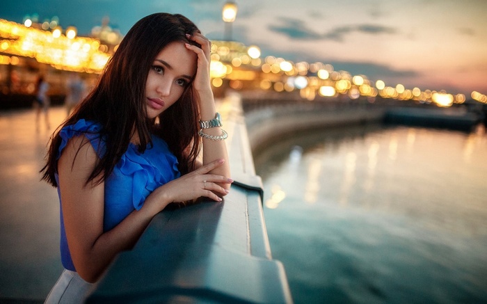 Woman leaning on a railing at dusk