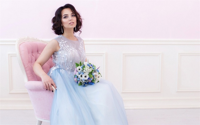 Woman in a blue dress holding a bouquet
