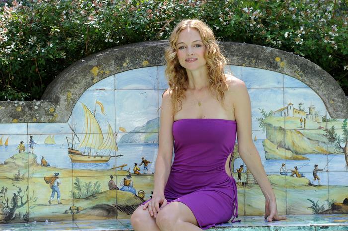 Heather Graham sitting on a tiled bench
