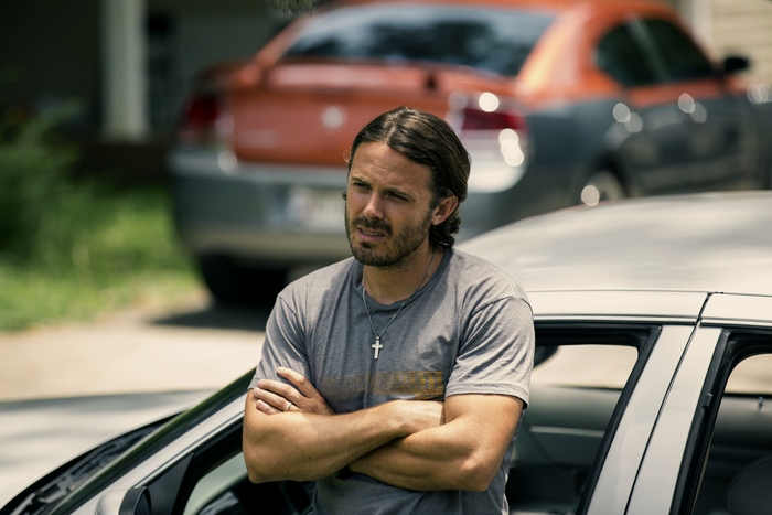 Casey Affleck leaning on a car