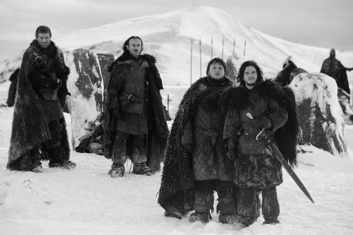 Four men in fur cloaks in a snowy landscape