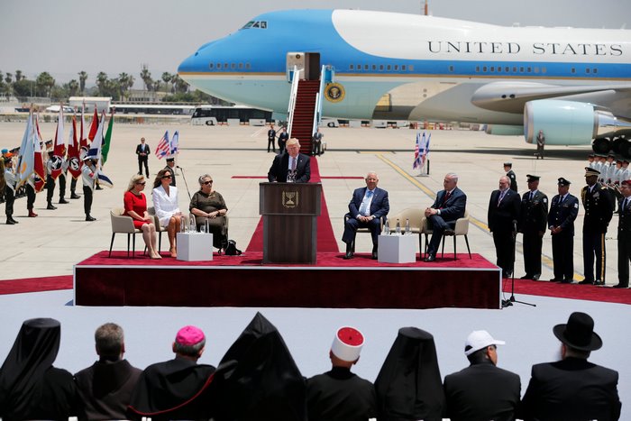 Donald Trump speaking at podium with Air Force One