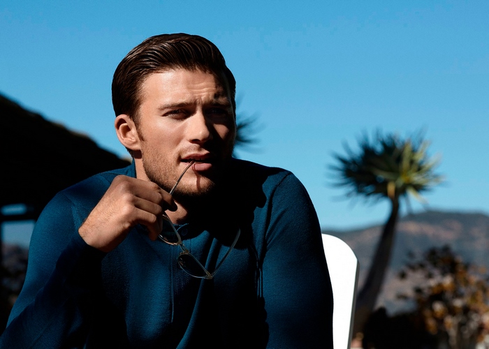 Scott Eastwood holding sunglasses