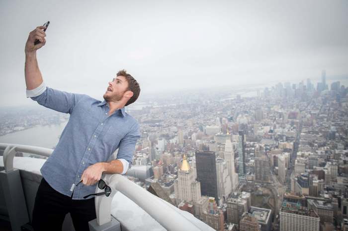 Scott Eastwood taking a selfie on a skyscraper