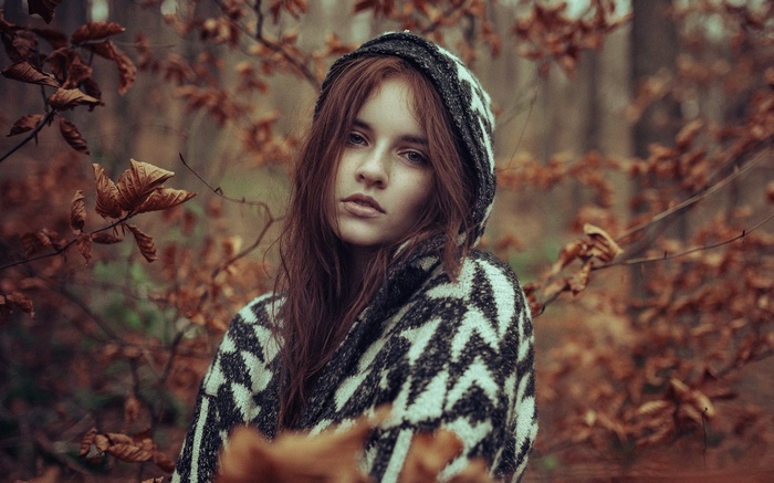 Young woman with red hair in a forest