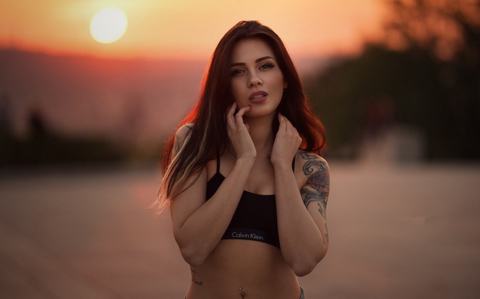 Woman with tattoos at sunset