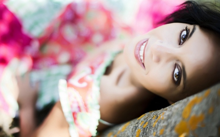 Woman with dark hair smiling outdoors