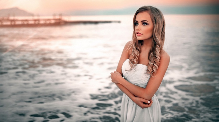 Woman in white dress by the sea