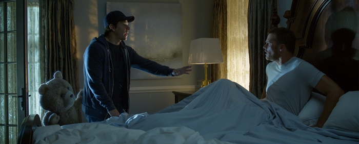 Tom Brady and a teddy bear in a bedroom