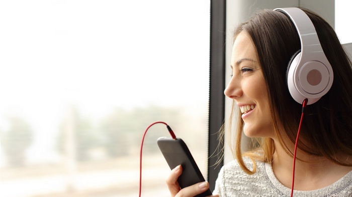 Woman listening to music on phone with headphones