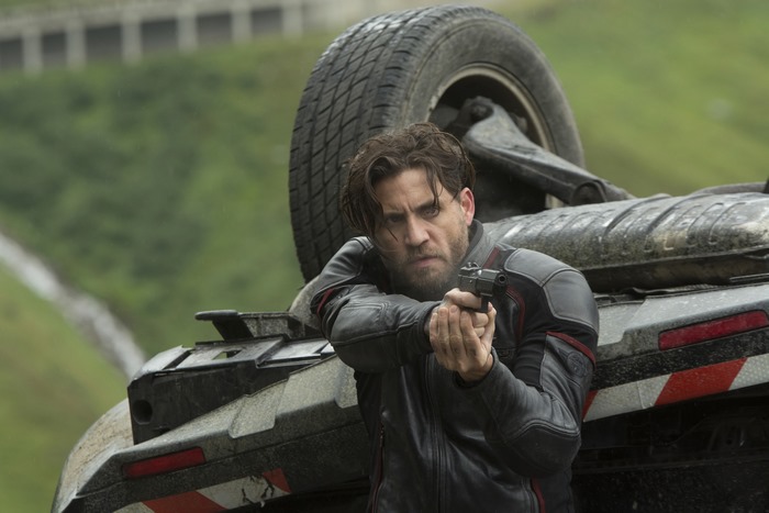 Edgar Ramirez with a gun near a crashed car