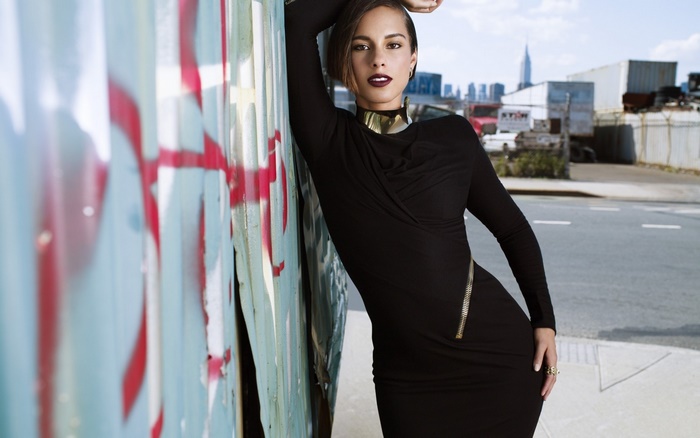 Alicia Keys leaning against graffiti wall in New York